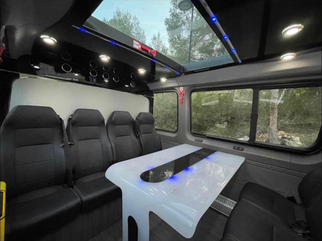 Lounge seating, table and lighting inside the party bus
